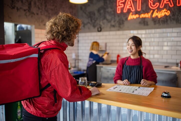 Food delivery person at the fast food restaurant waiting to pick up the order